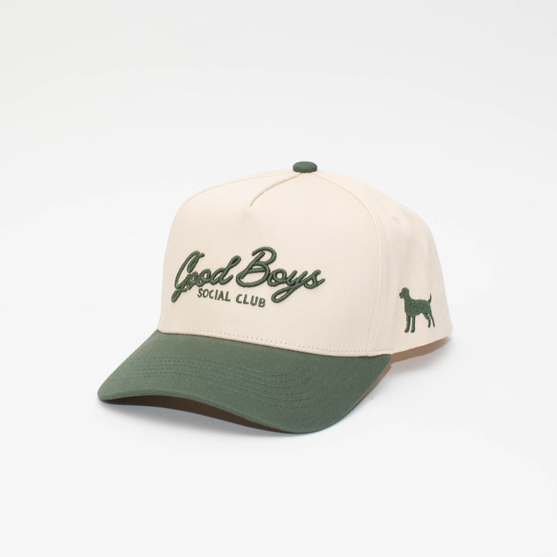 Angled view of the Hunter Green hat with a cream crown, green brim, Good Boys Social Club embroidery, and side dog silhouette.