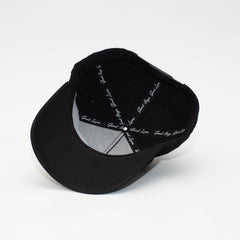 Interior of the Black Label black hat showing branded seam tape, black sweatband, and underside of the brim.